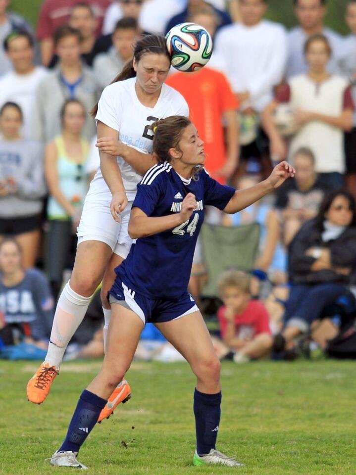 Corona del Mar High's Brianna Westrup, left, heads the ball against Newport Harbor's Sianna Siemonsma, right, during the first half in the Battle of the Bay match on Tuesday.