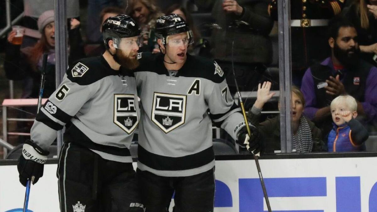 Kings center Jeff Carter, right, celebrates with defenseman Jake Muzzin after scoring against the Minnesota Wild at Staples Center on Saturday.