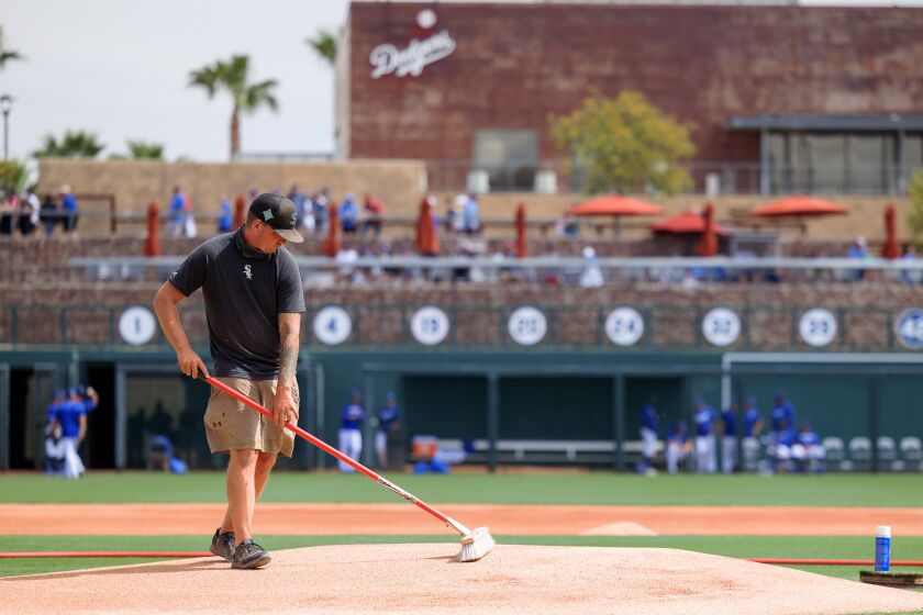 GLENDALE, AZ - MARCH 20: A groundsman prepares the pitchers mound before the MLB Spring Training.