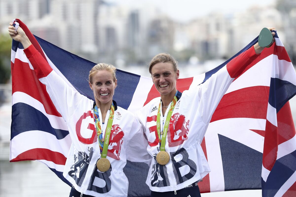 FILE - Britain's gold medalists Helen Glover, left, and Heather Stanning pose for photographs with their medals after the medal ceremony for the women's rowing pair rowing event at the Summer Olympics in Rio de Janeiro, Brazil, Friday, Aug. 12, 2016. Two-time Olympic rowing champion Helen Glover is making another comeback in a bid to qualify for a fourth Summer Games, saying she will be representing a “whole community of parents" in elite sport. (Ezra Shaw/Pool Photo via AP, File)