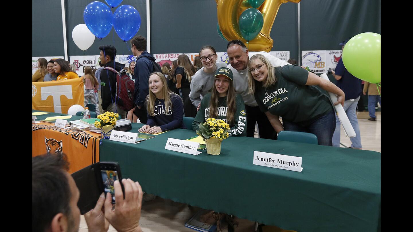 Maggie Gunther, center, poses for a picture with family and friends during a signing day ceremony at Edison High on Thursday.