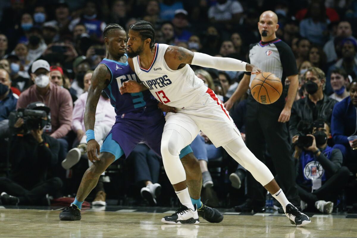 Los Angeles Clippers forward Paul George (13) dribbles against Charlotte Hornets guard Terry Rozier (3) during the first half of an NBA basketball game Sunday, Nov. 7, 2021, in Los Angeles. (AP Photo/Ringo H.W. Chiu)
