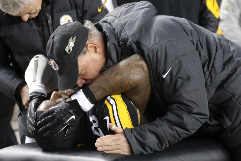 Pittsburgh Steelers running back Le'Veon Bell listens to a trainer after being injured in the third quarter against the Cincinnati Bengals on Dec. 28, 2014.