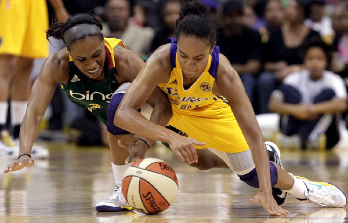 Sparks guard Kristi Toliver tries to recover a loose ball against Storm guard Temeka Johnson in the first half Sunday at Staples Center.