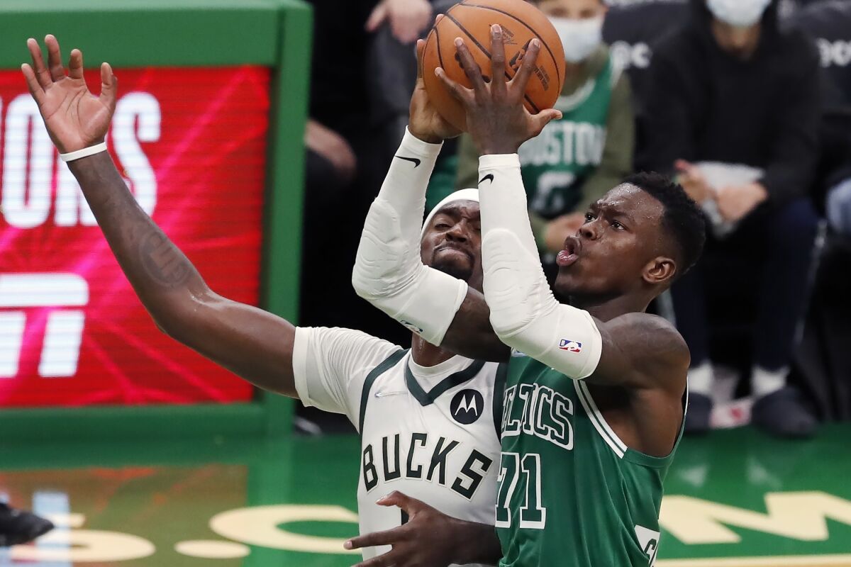Boston Celtics' Dennis Schröder (71) shoots against Milwaukee Bucks' Bobby Portis in overtime of an NBA basketball game Friday, Nov. 12, 2021, in Boston. (AP Photo/Michael Dwyer)