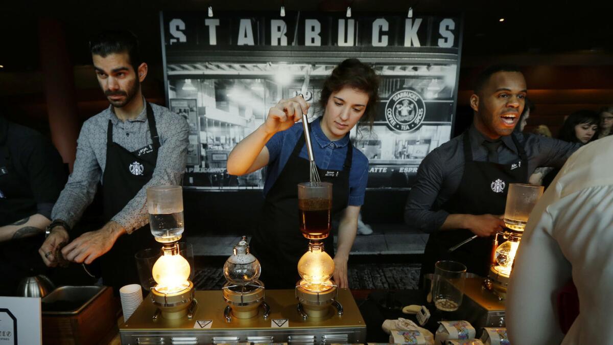 Starbucks workers prepare coffee during the company's shareholder meeting in Seattle in March.