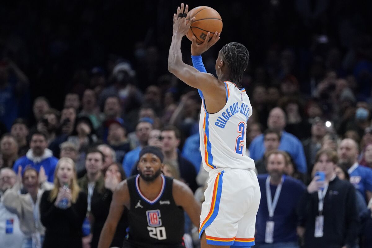 The Thunder's Shai Gilgeous-Alexander shoots a game-winning three-pointer as the Clippers' Justise Winslow looks on.