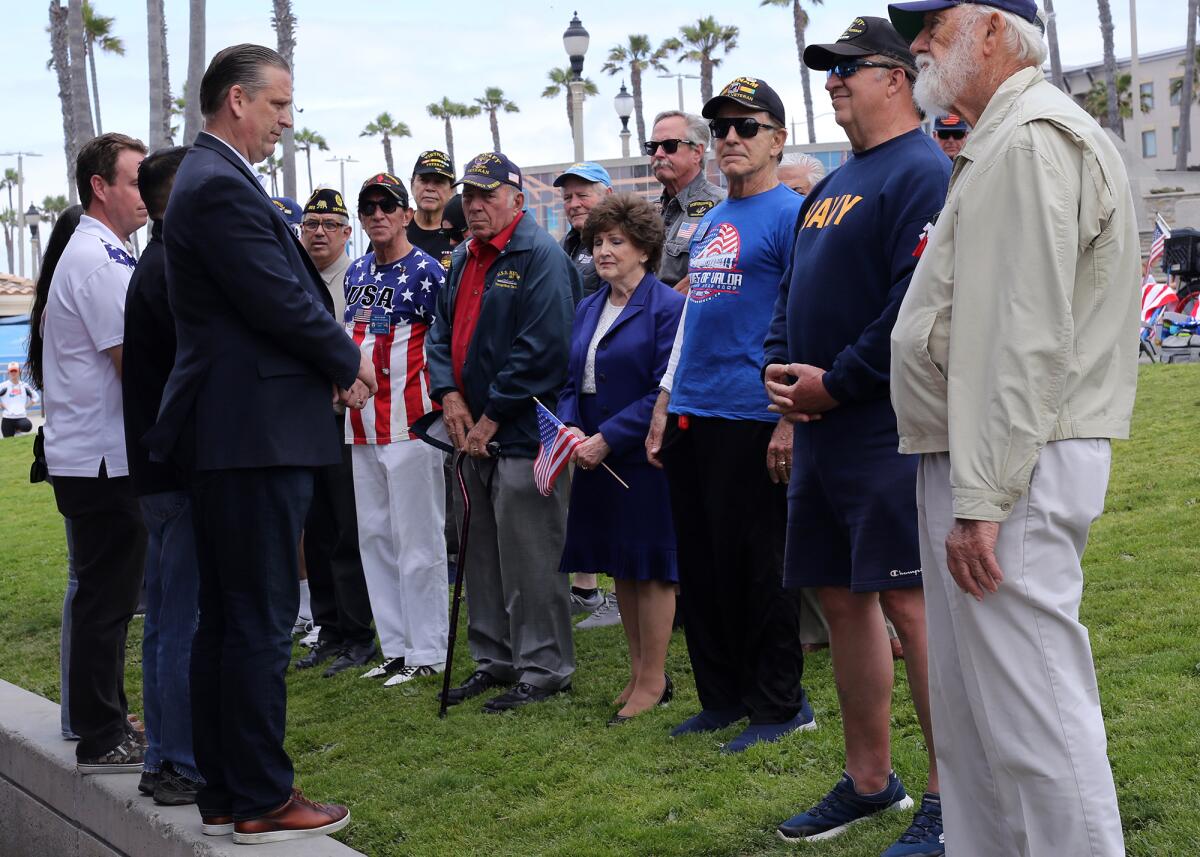 Huntington Beach Mayor Tony Strickland, left, stands with veterans during a prayer.