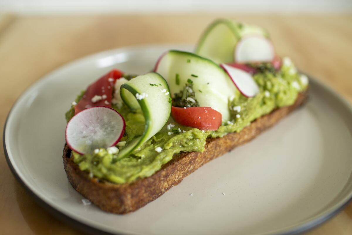 Avocado toast with slices of cucumber, tomato and radish at the Toast Kitchen & Bakery in Tustin.