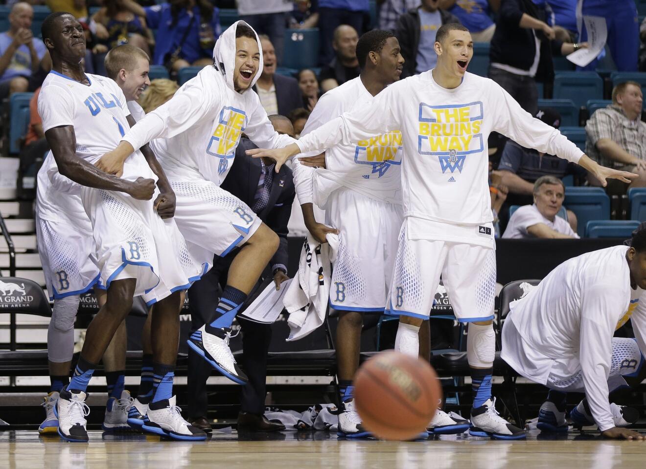 UCLA players on the bench react after a dunk by a teammate against Stanford in the second half Friday night at the Pac-12 Conference tournament semifinals in Las Vegas.