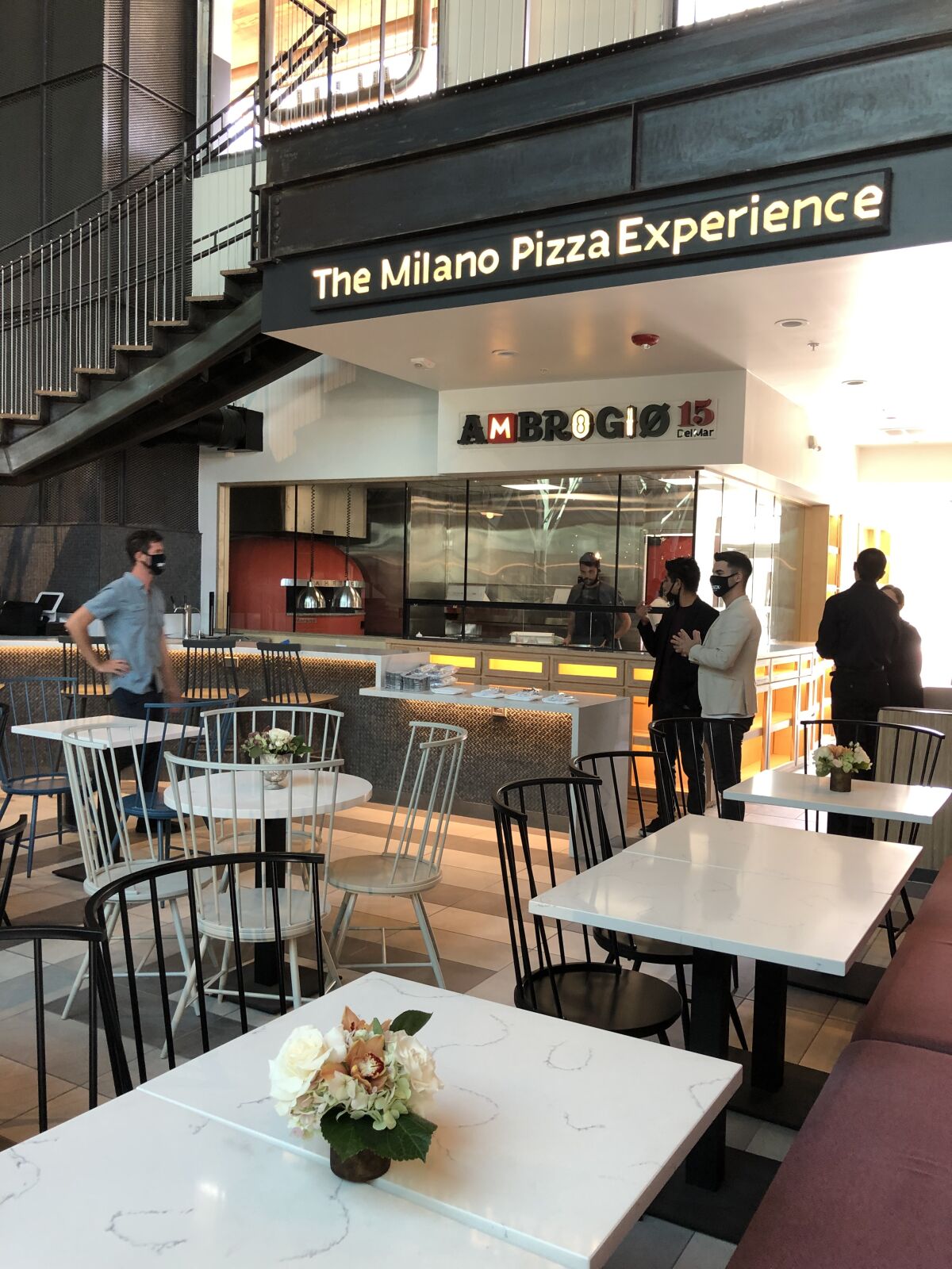 Owners and managers mingle at Ambrogio15, the Milano Pizza Experience, inside the Sky Deck food hall.