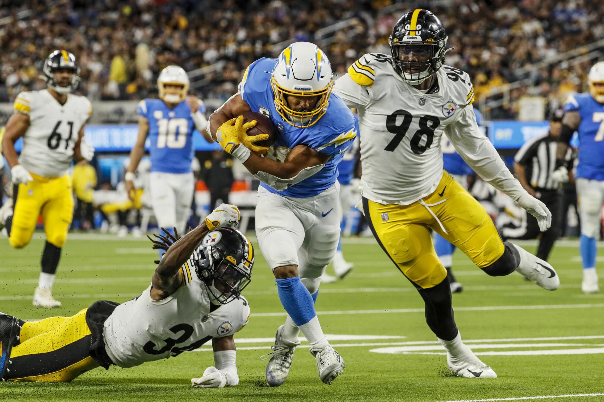 Chargers running back Austin Ekeler trudges into end zone in front of Pittsburgh's Tre Norwood and Taco Charlton.