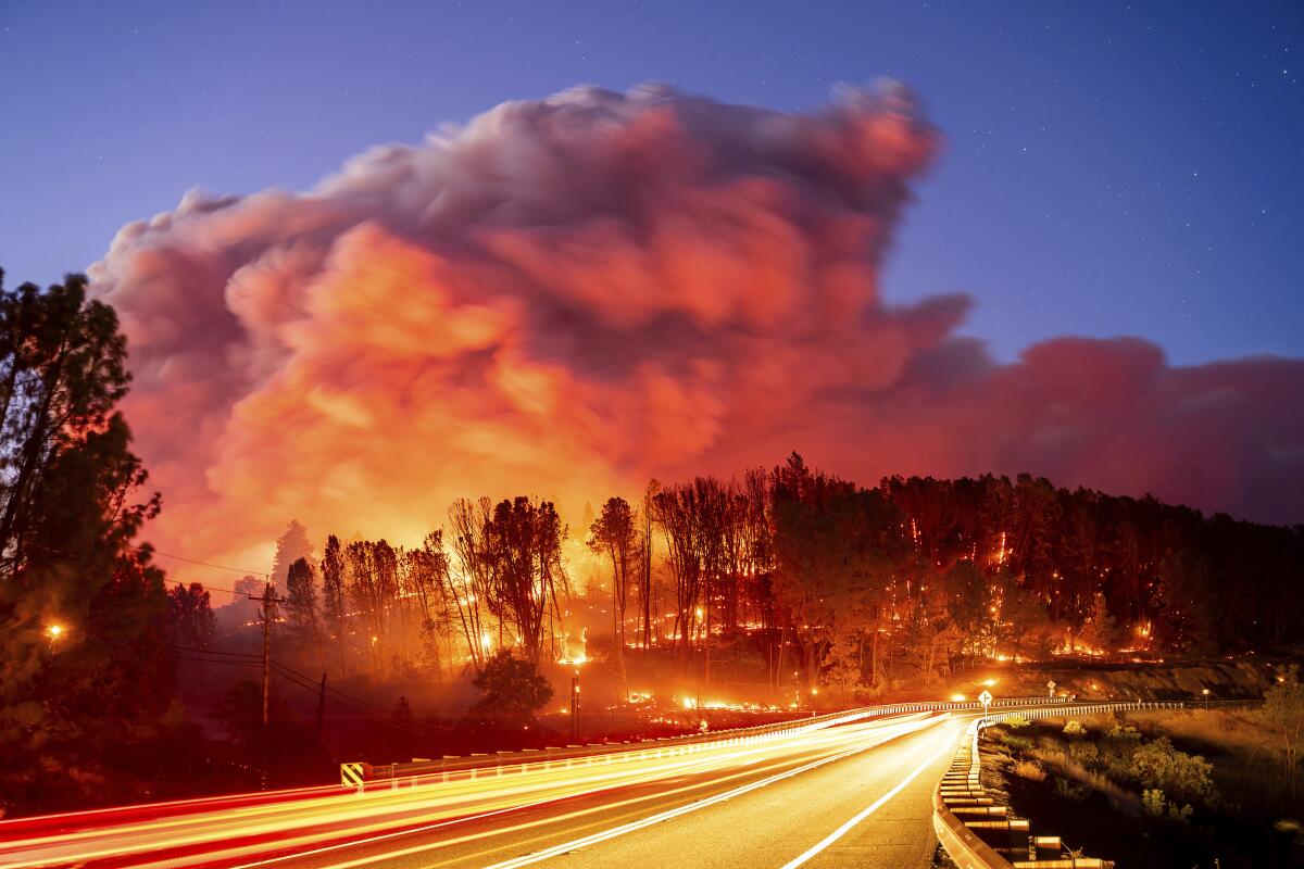 Seen in a long-exposure photo, the Park fire burns along Highway 32 in the Forest Ranch community of Butte County, Calif.
