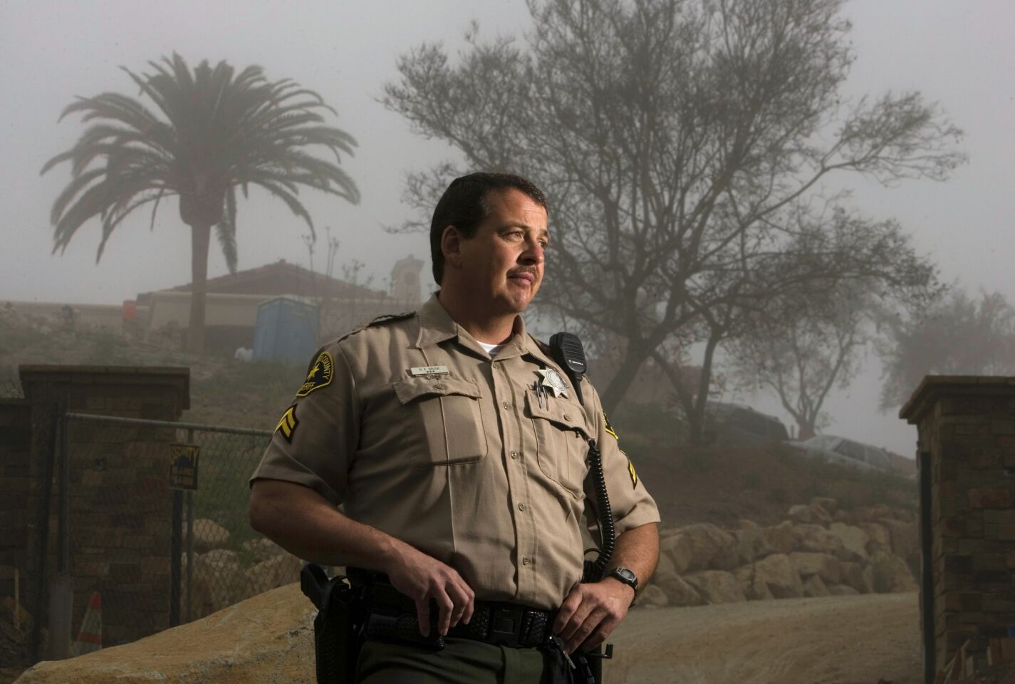San Diego Sheriff Deputy Robert Brunk stood near the entrance to the property in Rancho Santa Fe where 39 Heaven's Gate members committed mass suicide inside a mansion. Brunk, shown 10 years ago, was the first responder to the call that there was a problem at the house and found room after room of bodies on March 26, 1997. The mansion was razed but a new building was constructed at the site.