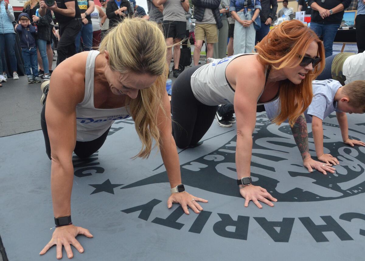 Bo Wind, left, and Stevie Fetters push-ups as a crowd watches.