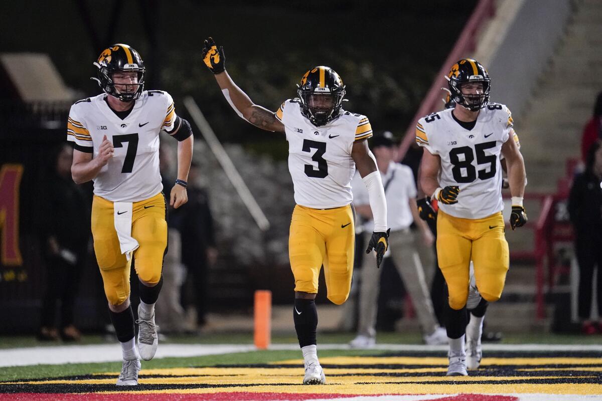Iowa's Tyrone Tracy Jr., center, celebrates his touchdown catch on a pass from Spencer Petras, left
