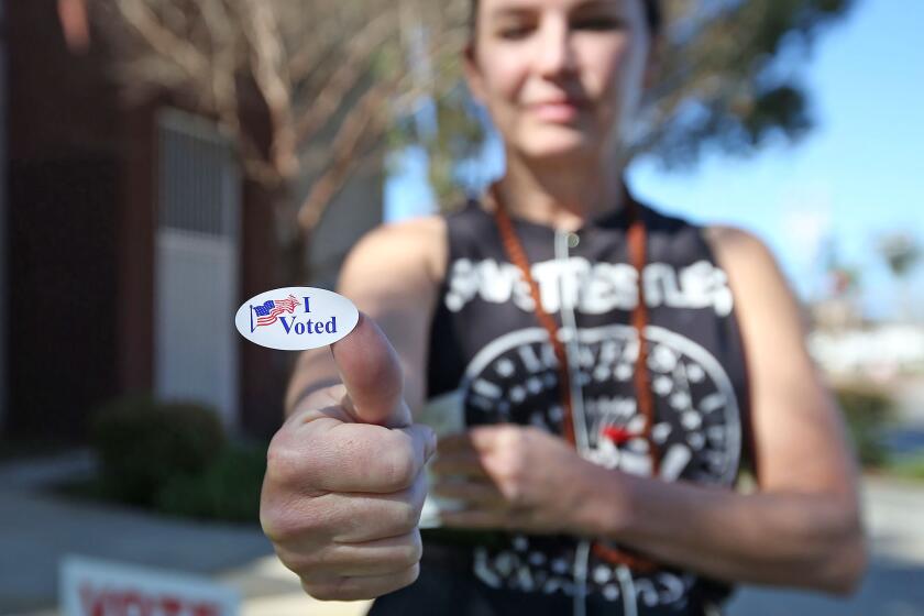 Sarah Stockstill, 48, artist, proudly shows her sticker after voting on Super Tuesday Election Day center at Costa Mesa Senior Center.