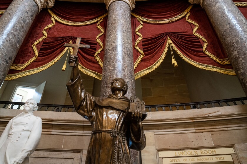 A statue of Junipero Serra, who holds a cross in one hand and a miniature mission in the other, at the U.S. Capitol