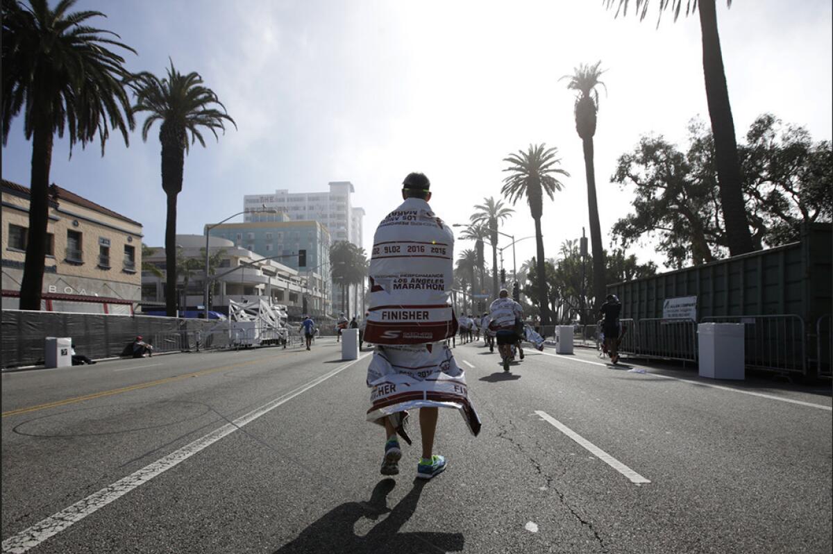 A runner walks along Ocean Boulevard in Santa Monica after completing the L.A. Marathon.