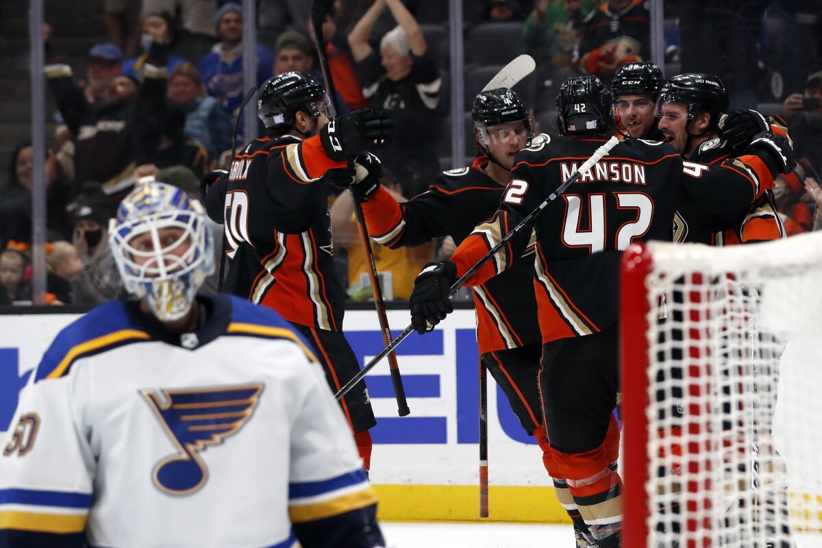 Ducks center Sam Carrick, right, celebrates scoring against St. Louis Blues goaltender Jordan Binnington.