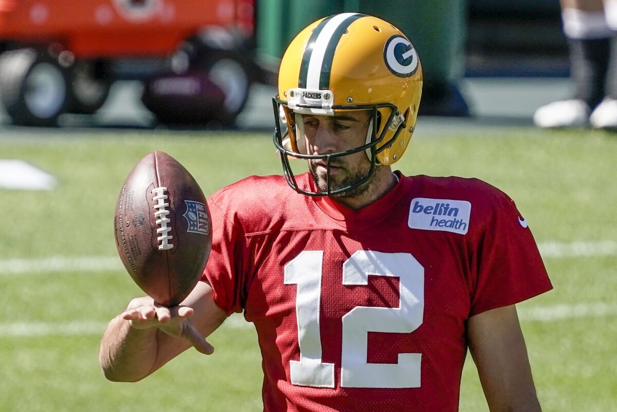 Green Bay Packers' Aaron Rodgers plays with a football during NFL football practice.