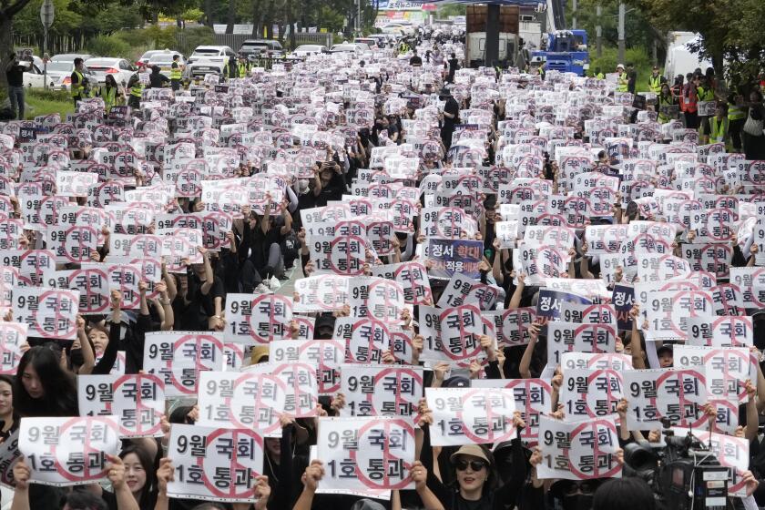 Profesores y personal de escuelas surcoreanas sostienen carteles durante una marcha para exigir mejores protecciones de sus derechos, cerca de la Asamblea Nacional en Seúl, Corea del Sur, el sábado 16 de septiembre de 2023. (AP Foto/Ahn Young-joon).