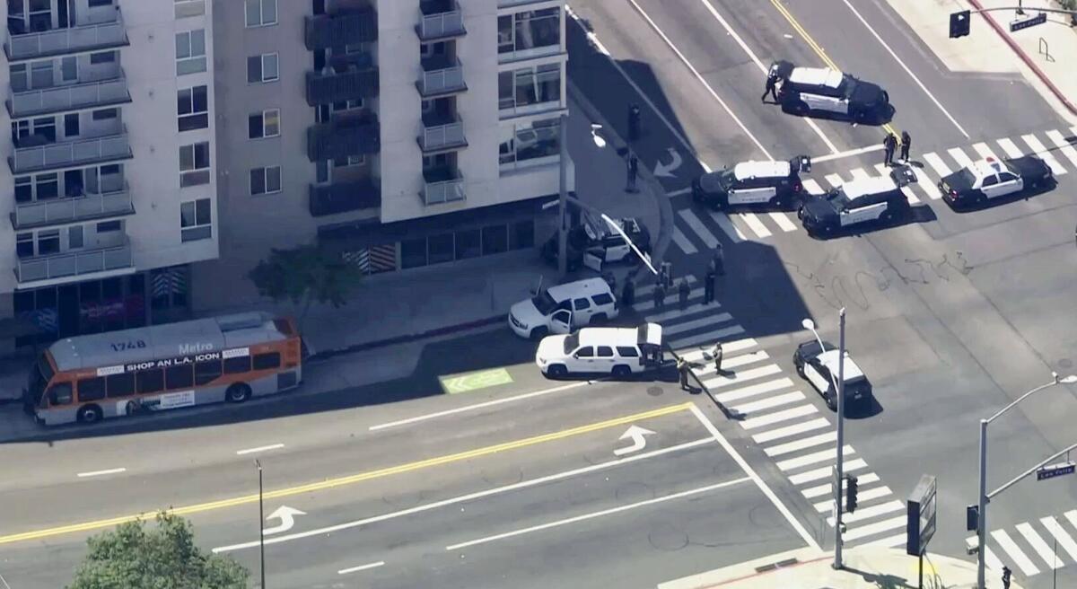 An aerial view of police vehicles behind a bus.
