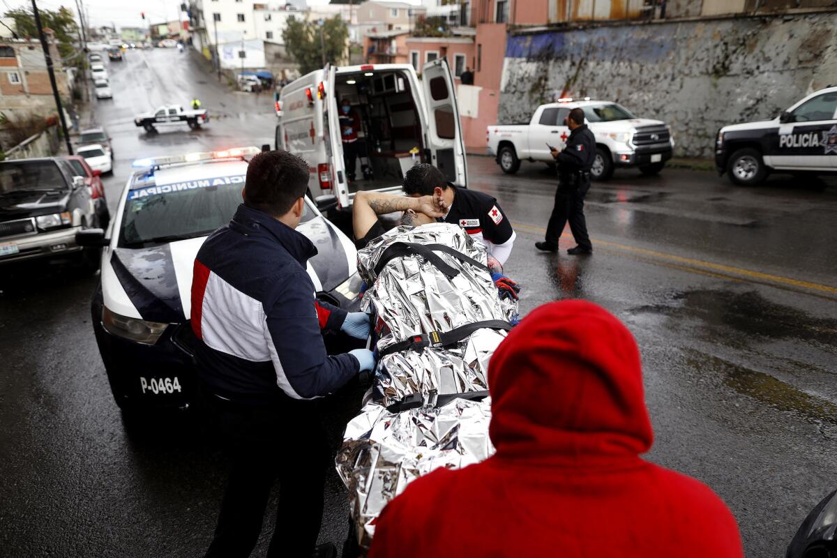 Paramedics with Tijuana Red Cross prepare to transport a shooting victim to Tijuana General Hospital.