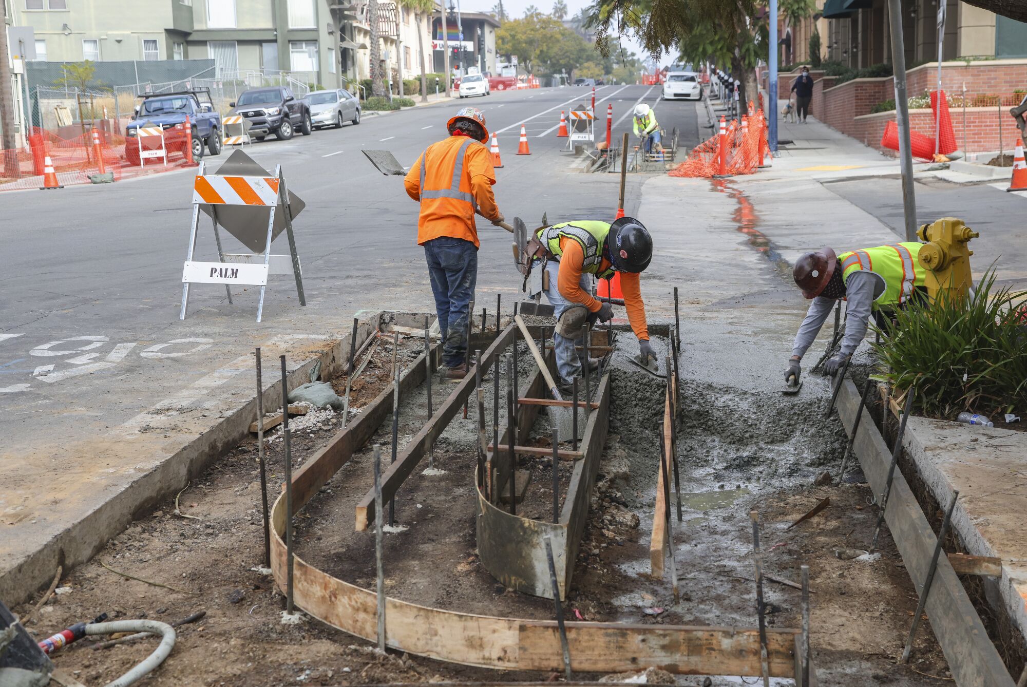 Construction crews work on a parking-protected bike lane at the corner of 4th Avenue and Kalmia Street near Balboa Park.