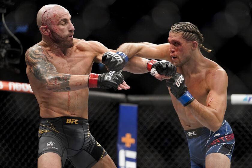 Alexander Volkanovski, left, exchanges punches with Brian Ortega during a featherweight mixed martial arts title bout at UFC 266, Saturday, Sept. 25, 2021, in Las Vegas. (AP Photo/John Locher)