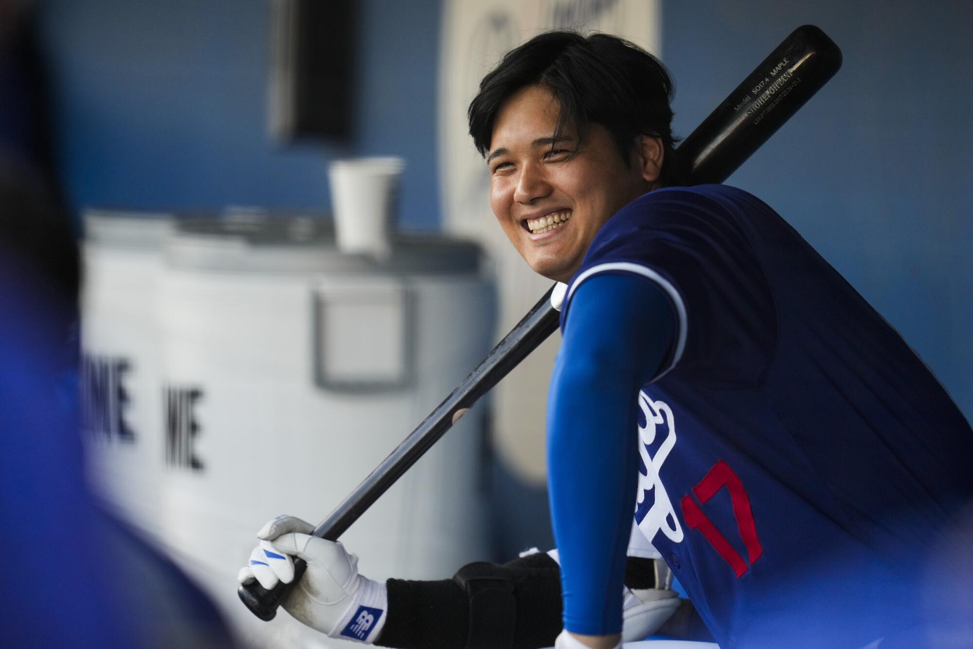 Dodgers'ın atanmış smaçör Shohei Ohtani, bahar antrenman maçı öncesinde sığınakta gülümsüyor.