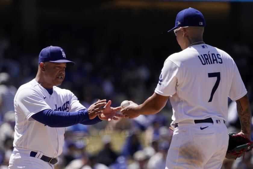 Los Angeles Dodgers manager Dave Roberts, left, takes starting pitcher Julio Urias out.