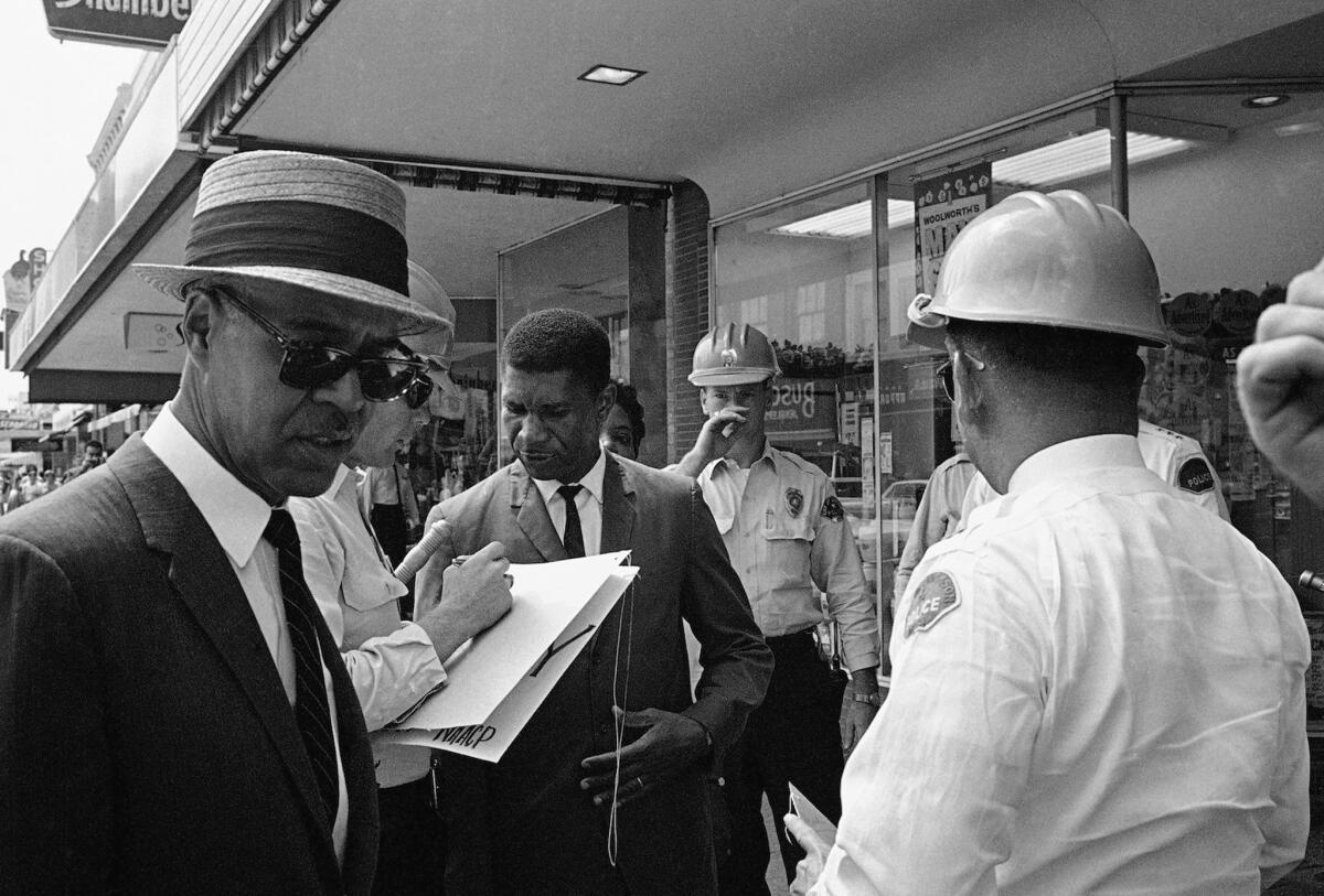Roy Wilkins, left, executive secretary of the NAACP, and Medgar Evers, center, field secretary of the NAACP, are arrested for picketing in downtown Jackson, Miss.