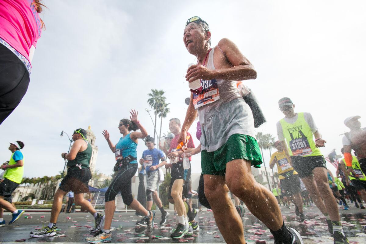 Los Angeles Marathon runners revel under a cold spray of water at the water station at mile marker 16 in Beverly Hills during the 2015 race. More than 30 people were hospitalized because of the heat.