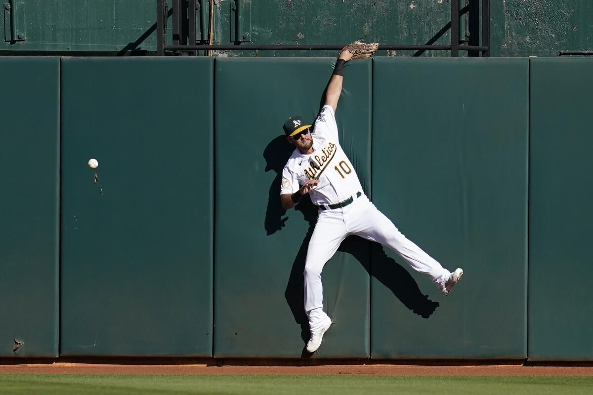 Oakland Athletics right fielder Chad Pinder cannot catch a triple hit by Seattle Mariners' Eugenio Suarez during the fourth inning of a baseball game in Oakland, Calif., Saturday, Aug. 20, 2022. (AP Photo/Jeff Chiu)