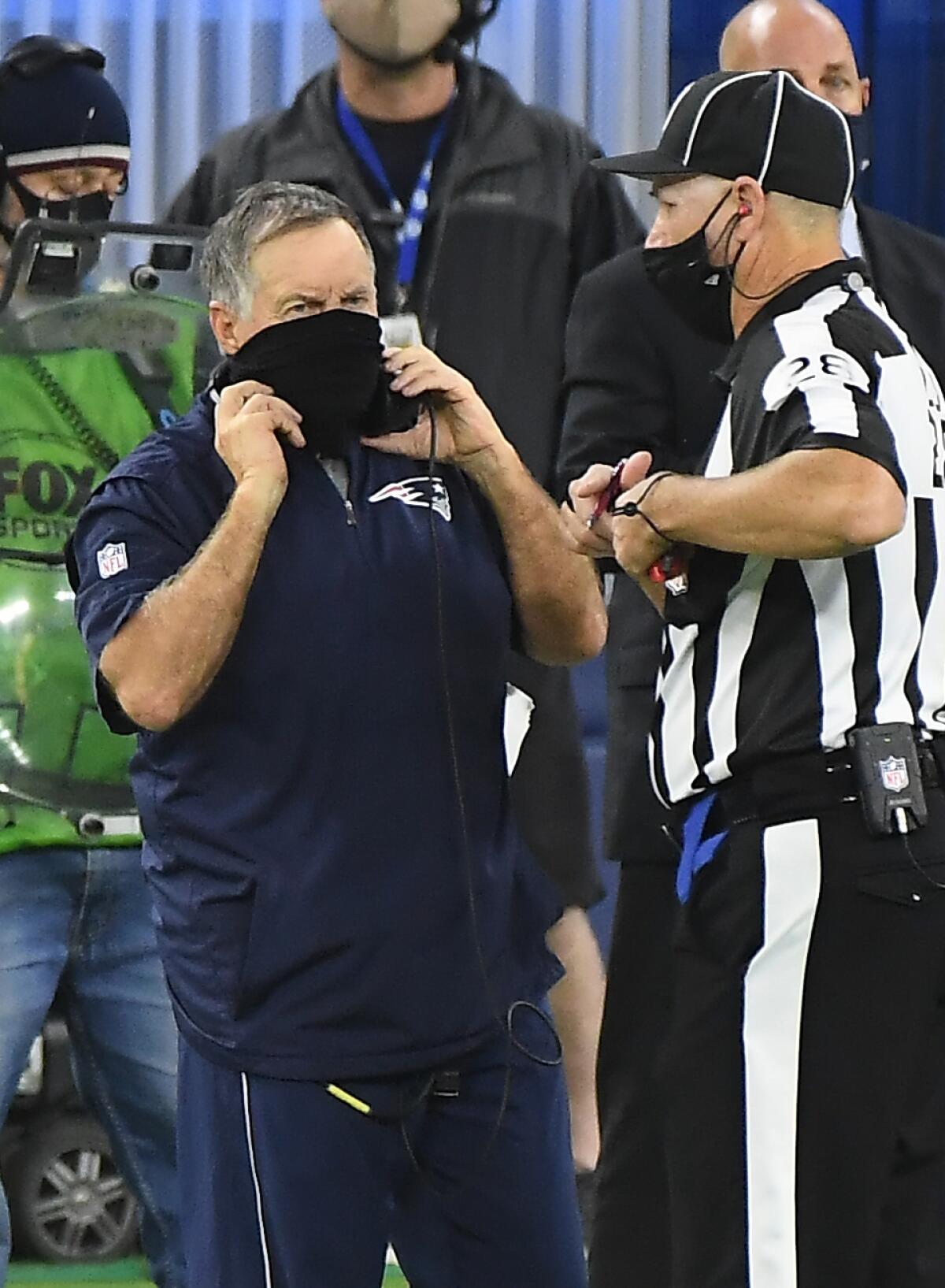 Patriots coach Bill Belichick talks with a referee.