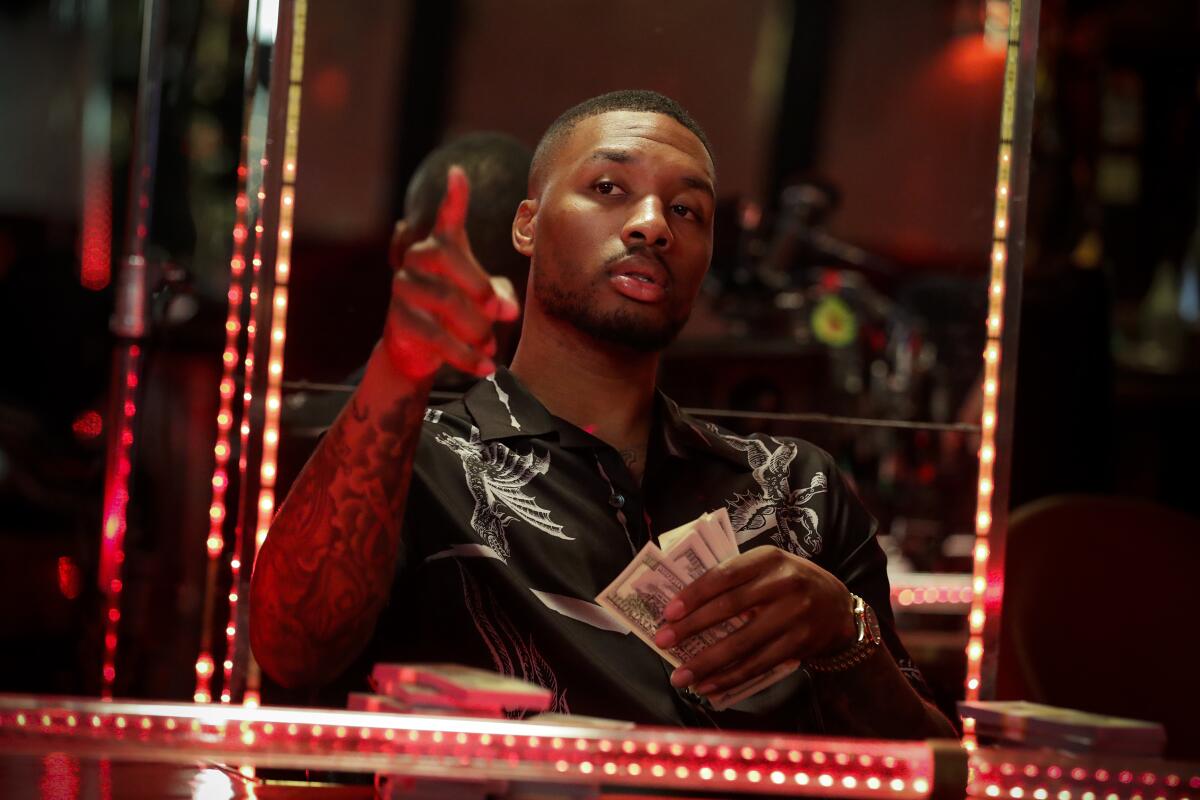 Damian Lillard of the Portland Trail Blazers holds cash during the photo shoot.