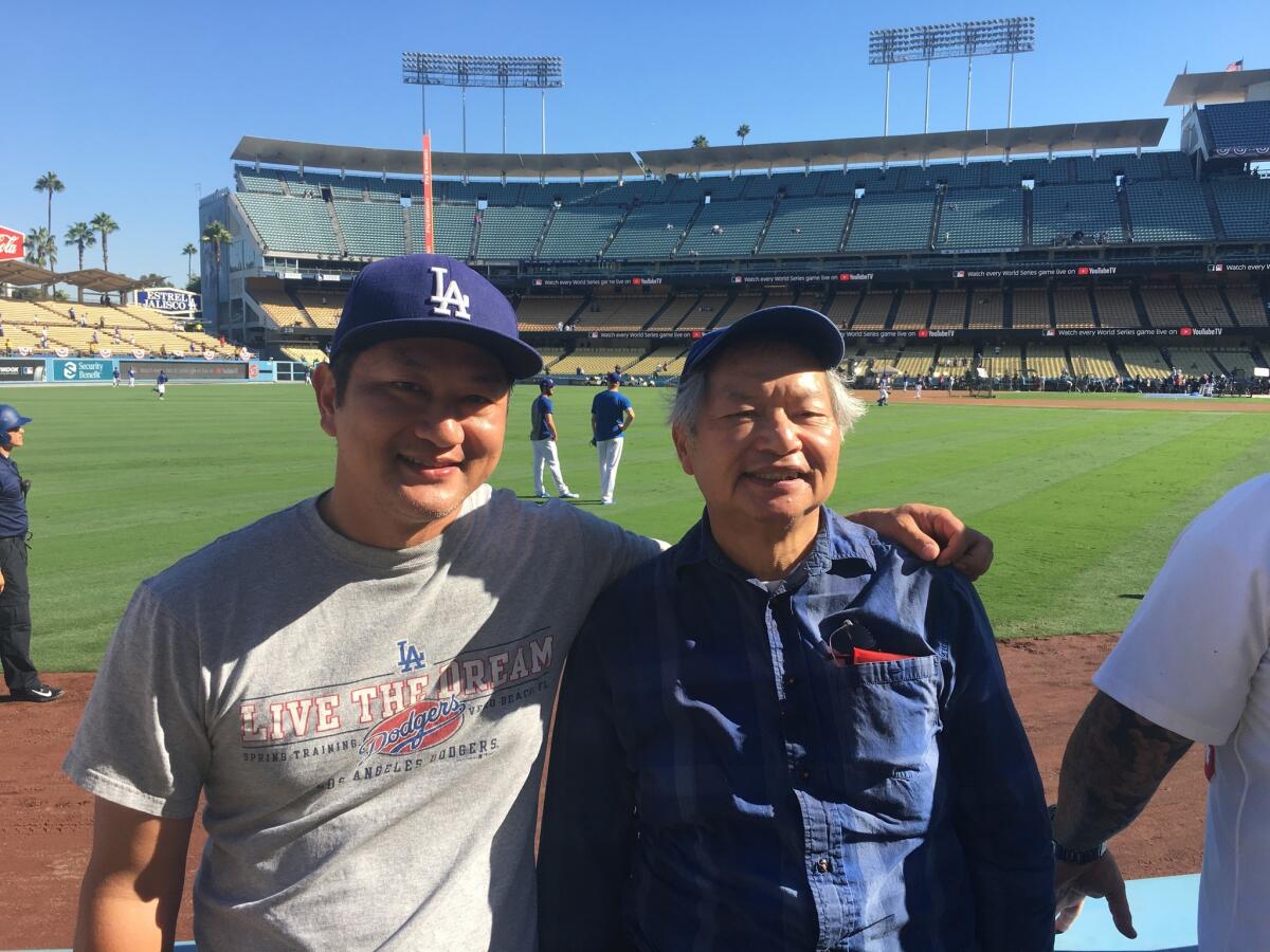 Jason and James Leong watch batting practice before Game 3 of the World Series.