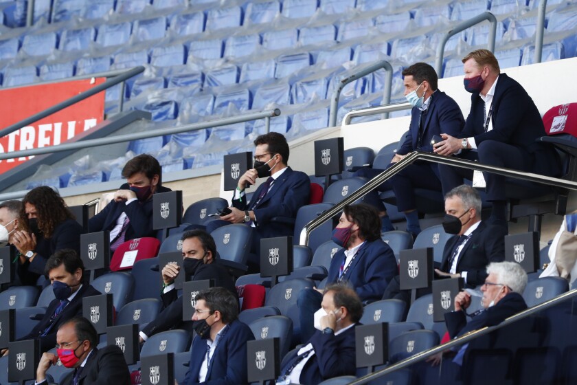 Barcelona's head coach Ronald Koeman, top right, watches from stands during the Spanish La Liga soccer match between FC Barcelona and Atletico Madrid at the Camp Nou stadium in Barcelona, Spain, Saturday, May 8, 2021. (AP Photo/Joan Monfort)