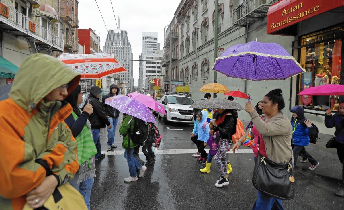 Pedestrians take cover in the Chinatown district of San Francisco as a powerful storm rolled into the Bay Area.