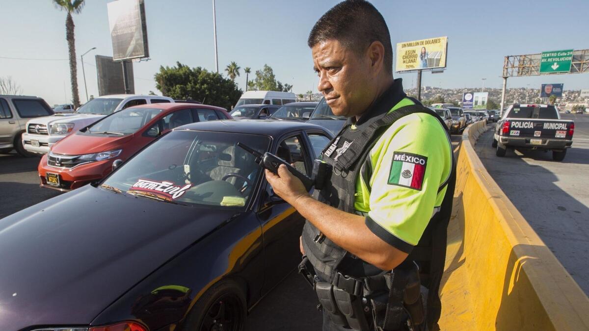 Martín Benítez Málaga, a supervisor with the tourism section of the Tijuana police department participates in the effort to stop people from cutting in lines as cars wait to cross in to the US.