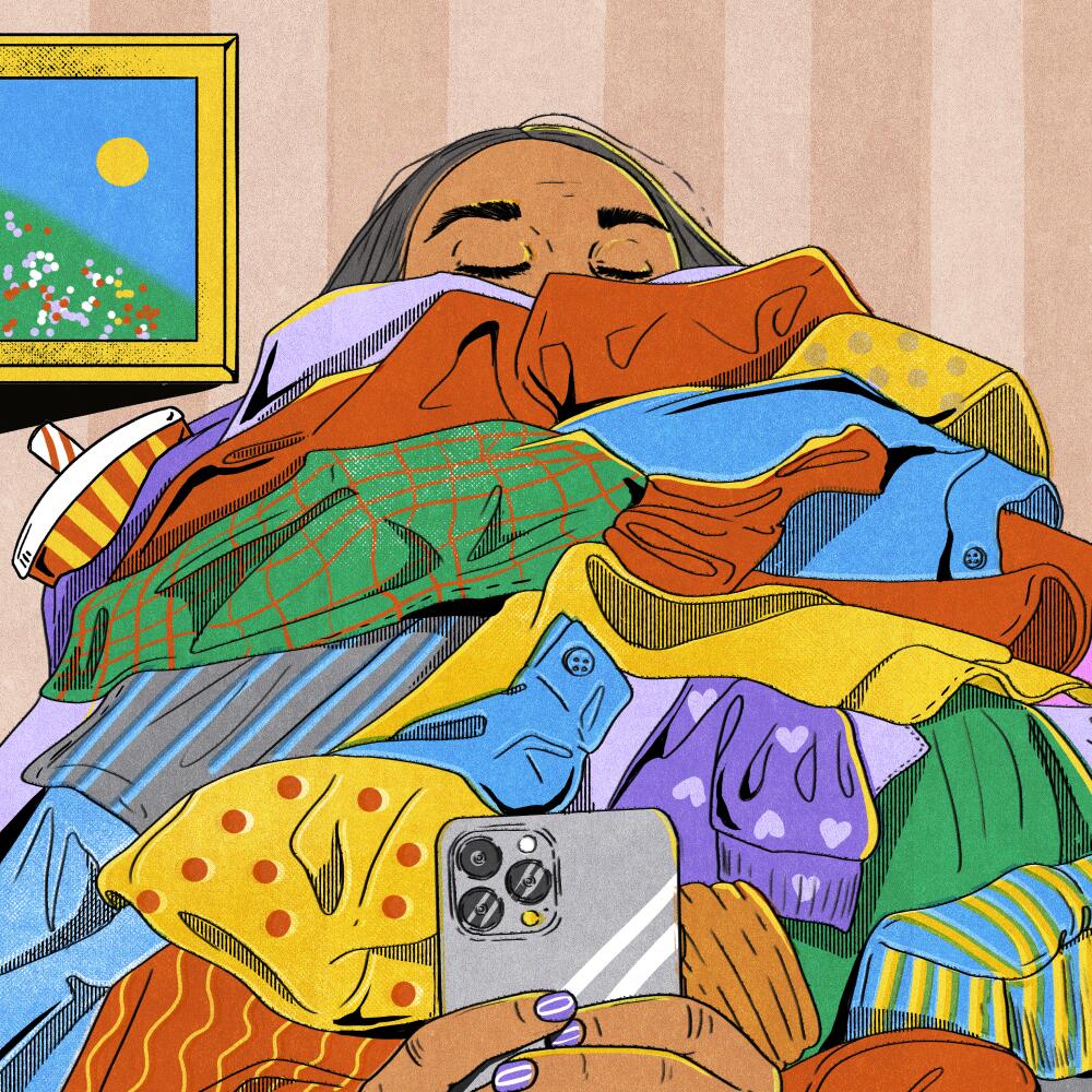 A woman, almost invisible under a pile of colorful clothes, takes a selfie.