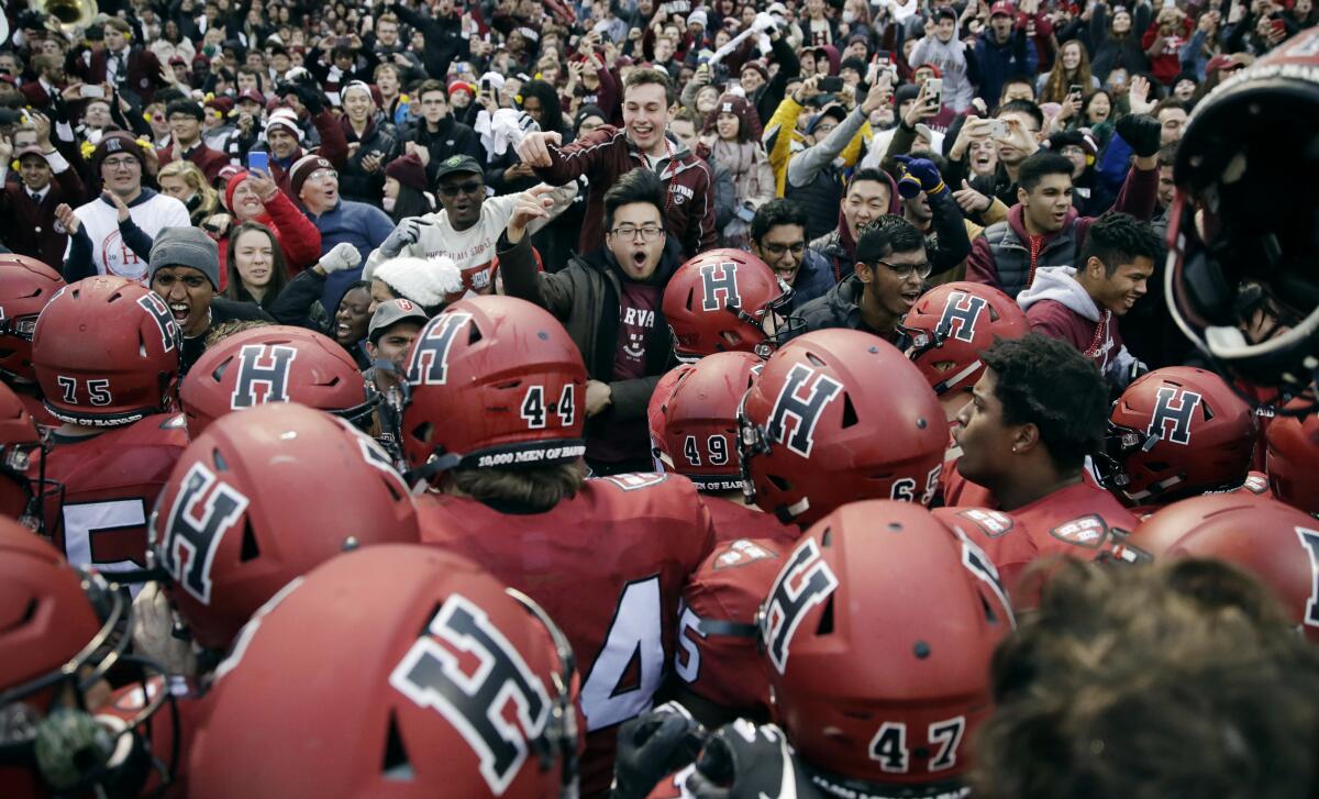 Harvard players, students and fans celebrate their 45-27 win over Yale at Fenway Park in Boston on Nov. 17, 2018.