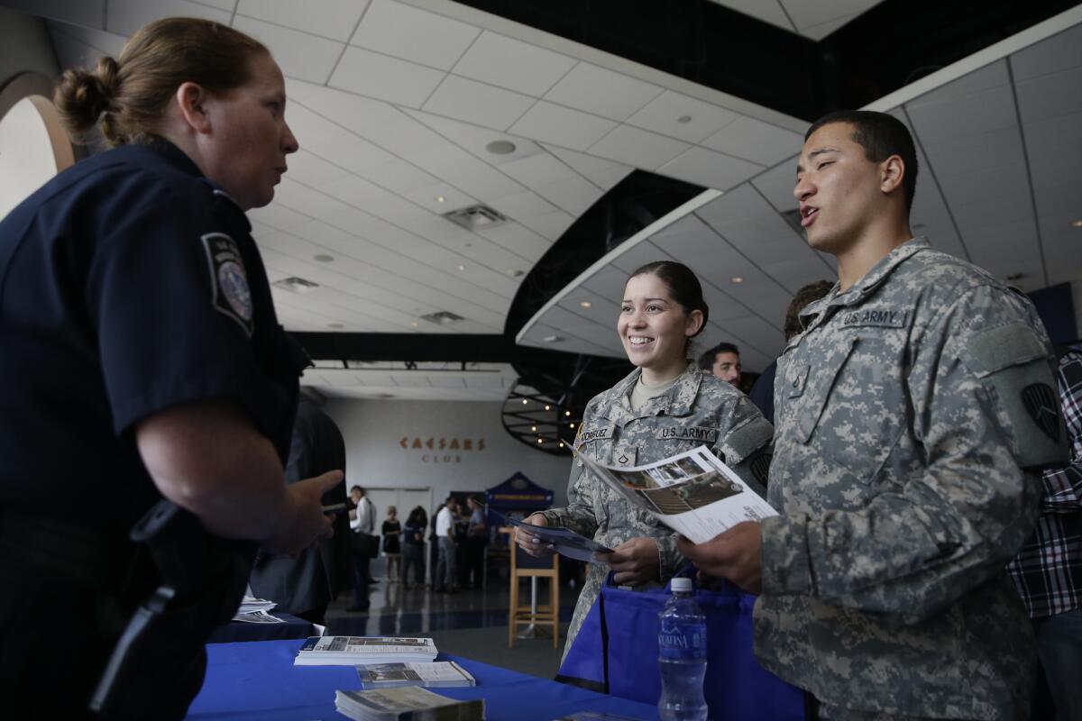 Kerry P. Gorman, left, with the Department of Homeland Security, speaks to Pfc. Melanie Rodriguez, center, of the Bronx, and Pfc. Anthony Sanelli, of Queens, about employment opportunities during a job fair at Citi Field in New York on June 30.