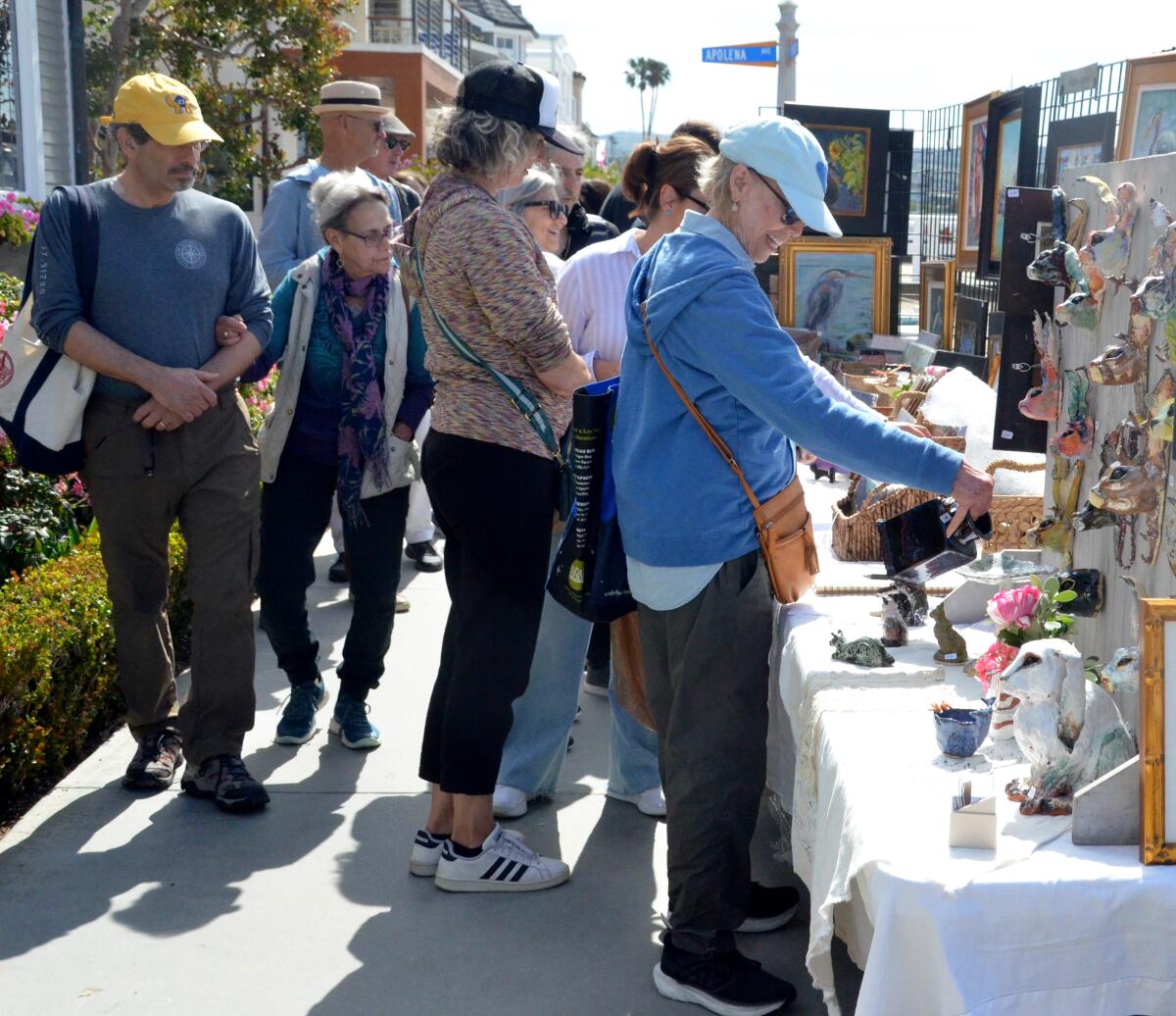 Attendees of Sunday's Balboa Island Artwalk South Bayfront inched along admiring the exhibits.