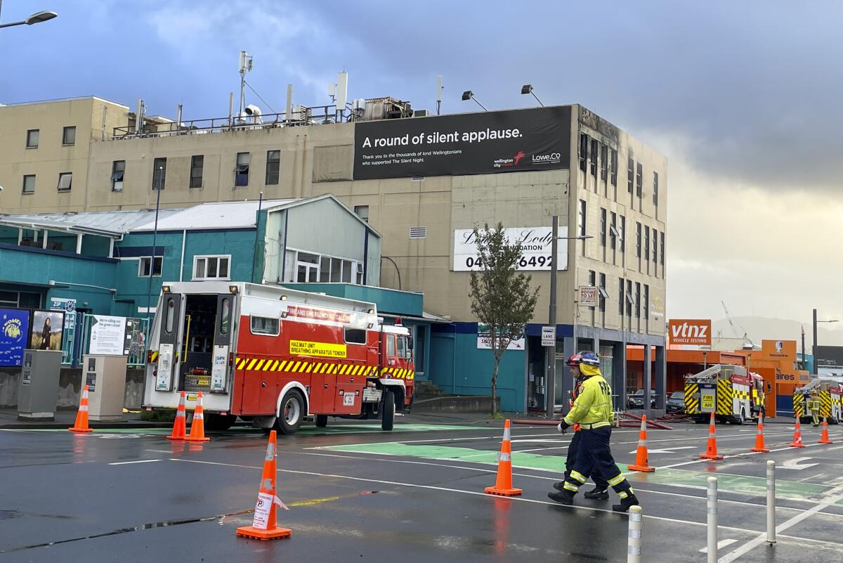 Firefighters work near a hostel in central Wellington, New Zealand