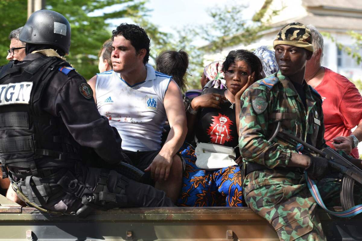 Ivorian security forces evacuate people after heavily armed gunmen opened fire at a hotel in the Ivory Coast beach resort of Grand-Bassam on March 13, 2016.