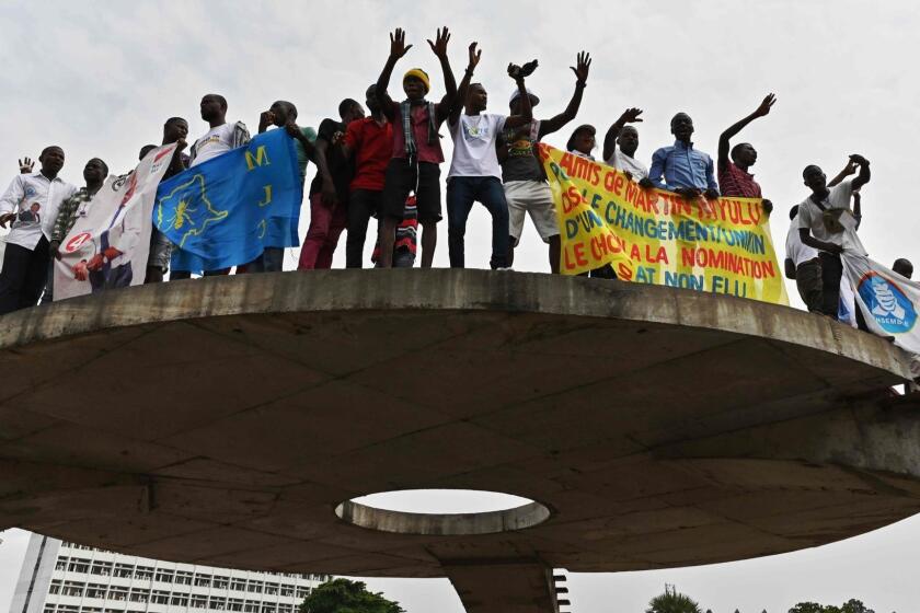 Supporters of opposition presidential candidate in the Democratic Republic of Congo, Martin Fayulu hold up a banner as they sing the Constitutional Court in Kinshasa on January 12, 2109 with his wife Esther after he filed his appeal to impose a recount of the votes in the presidential election following a suspicion of fraud. - The outcome of DR Congo's tempestuous presidential election appeared to be headed for the courts on January 11 after the poll's runner-up said he would demand a recount. Martin Fayulu, an opposition candidate tipped by pollsters as the likely winner of the December 30 vote and who came in a close second, dismissed the result and announced he will challenge the outcome before the Constitutional Court. (Photo by TONY KARUMBA / AFP)TONY KARUMBA/AFP/Getty Images ** OUTS - ELSENT, FPG, CM - OUTS * NM, PH, VA if sourced by CT, LA or MoD **