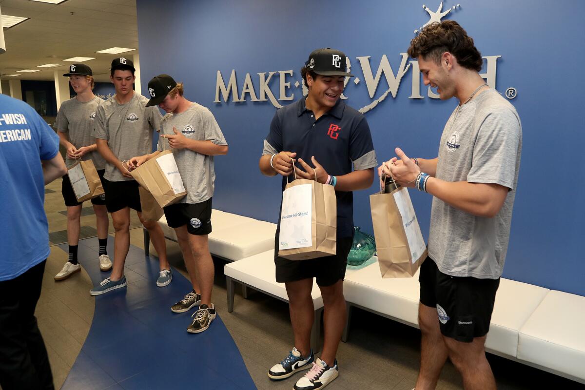 High school baseball players go through their gift bags at the Make-A-Wish Orange County & the Inland Empire headquarters.