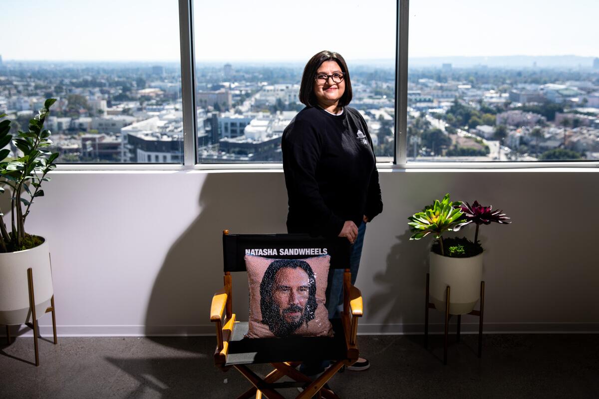 Nahnatchka Khan with a director's chair labeled "Natasha Sandwheels" and a pillow with the face of actor Keanu Reeves.